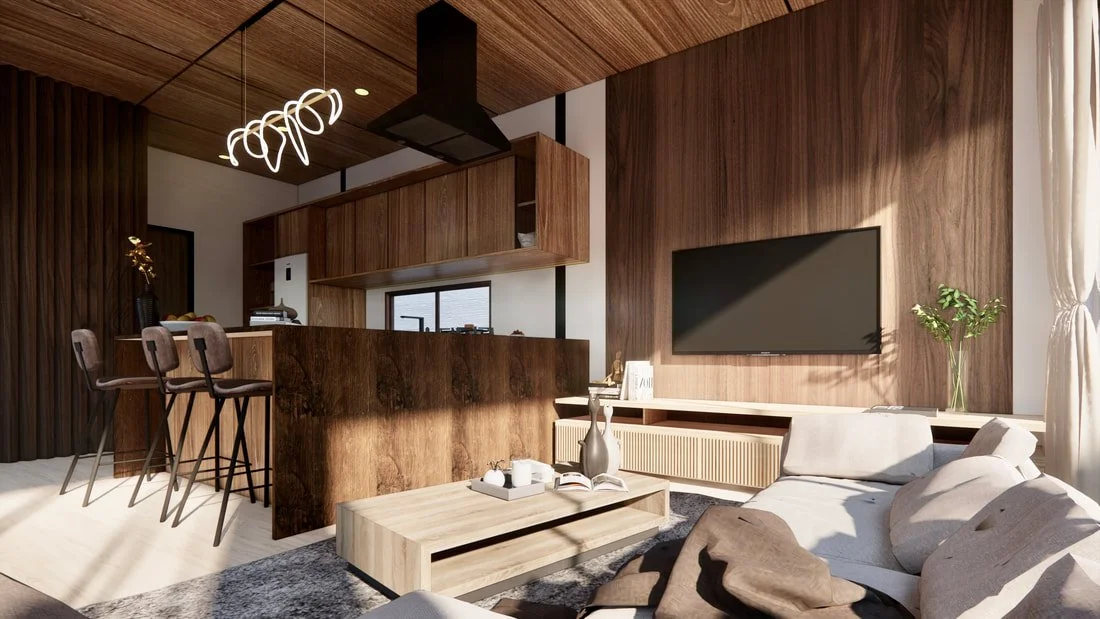 Modern living room with a wooden accent wall, a flat-screen TV, a white sofa with pillows, a coffee table with a vase and books, and a kitchen area with a wooden bar and chairs.