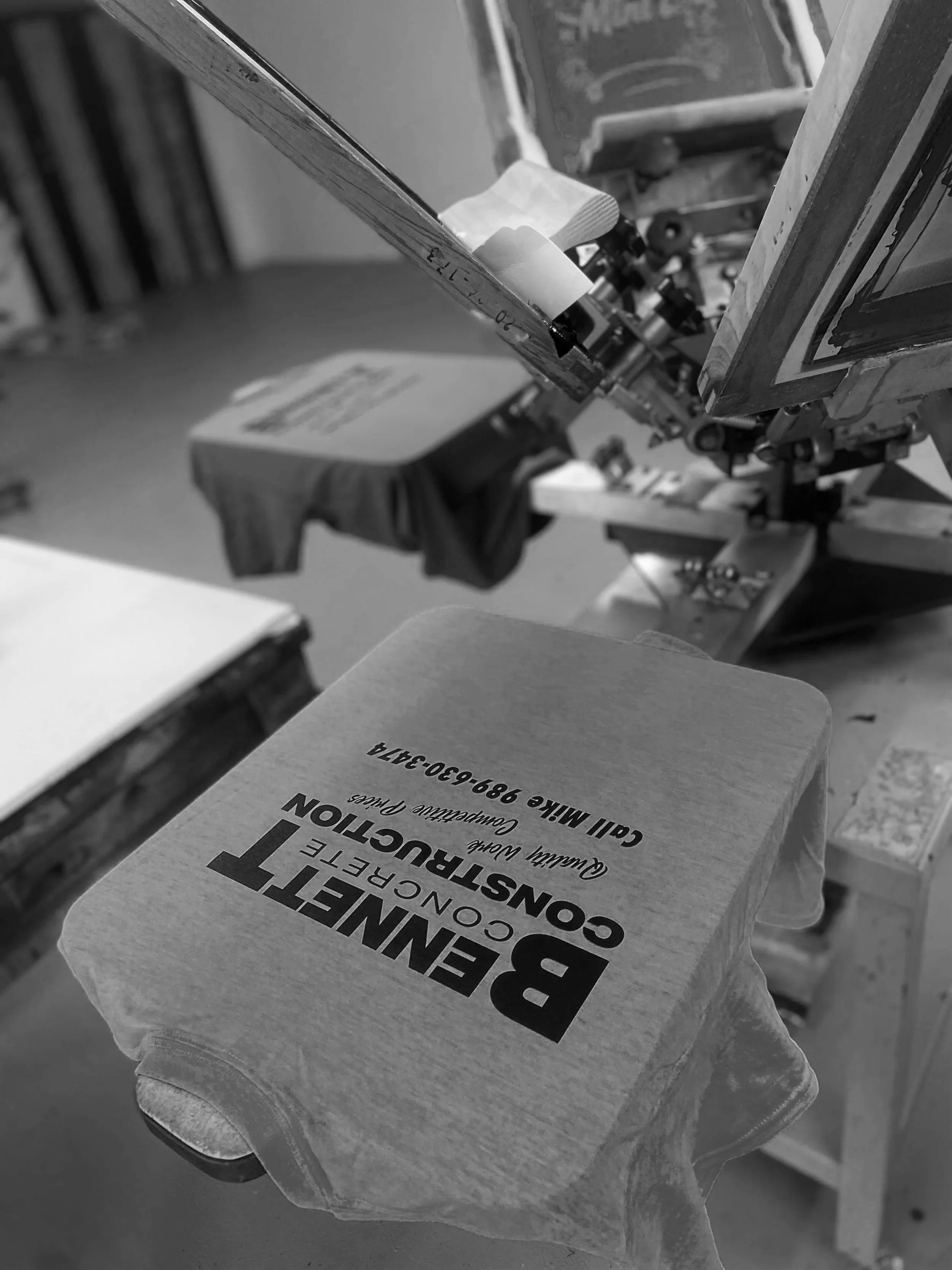 A cardboard box labeled 'BRENNETTE CONSTRUCTION' with additional text, underneath a workshop or storage area.