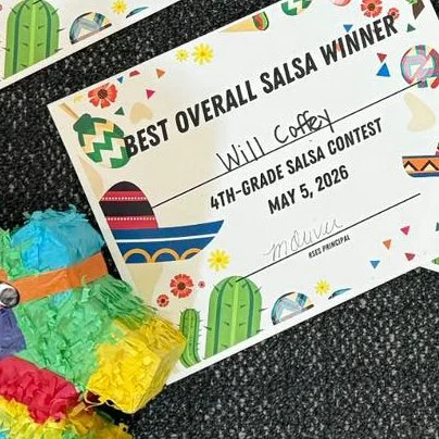 Certificate awarding Willie Cofer 4th grade salsa contest winner on May 5, 2026, with colorful Mexican-themed decorations including piñata and cactus illustrations.