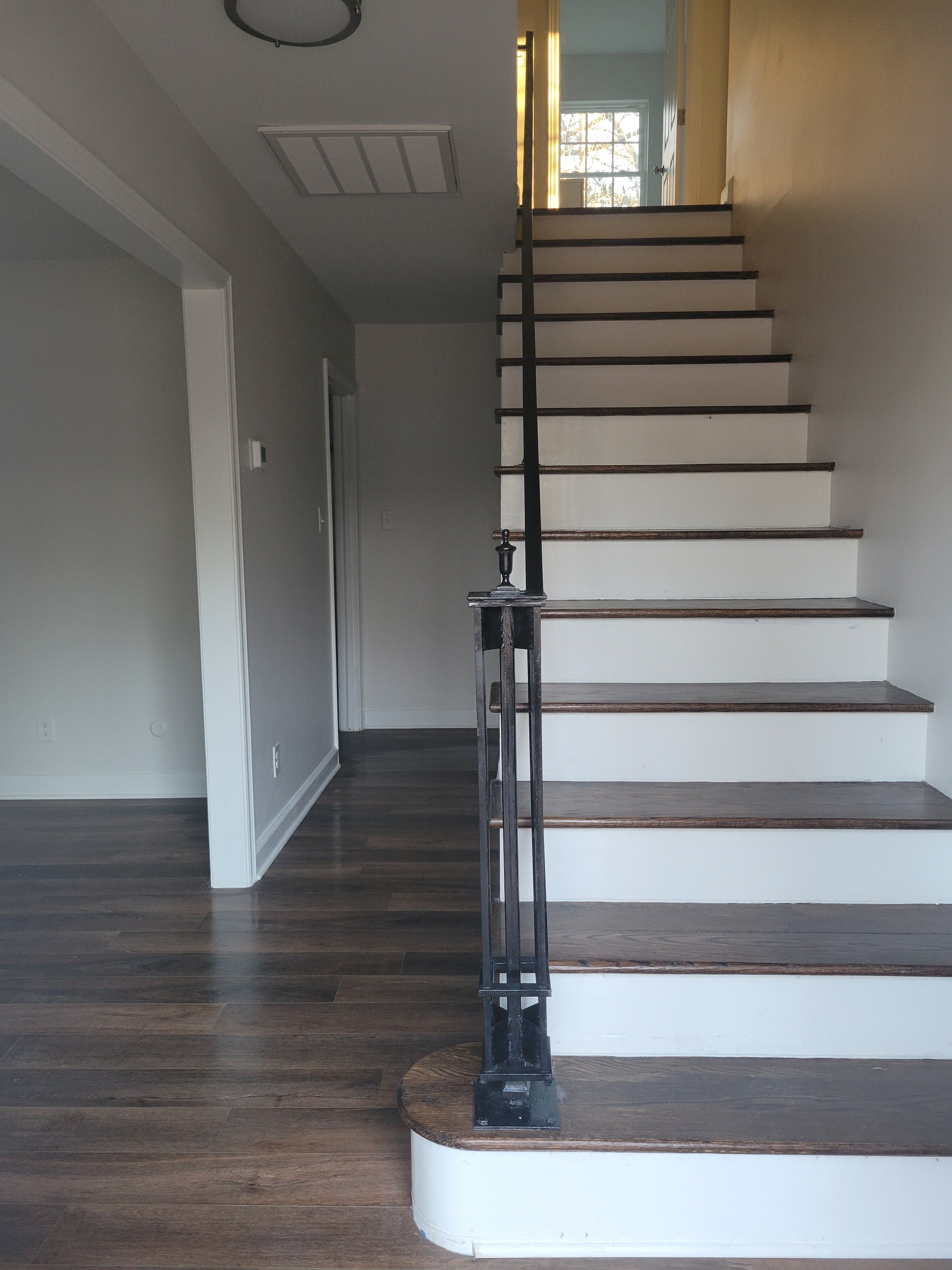 The original staircase banister was salvaged, it sandblasted and painted. The carpet was removed from the stairs and the hardwoods were refinished.