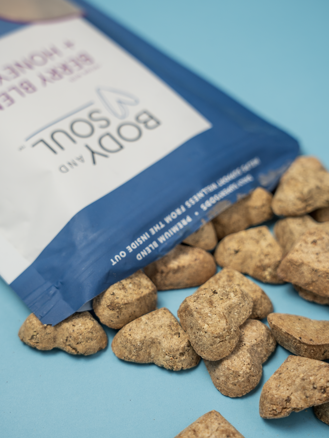A blue bag of Boppy and Spill rocks with some rocks scattered on a blue background.