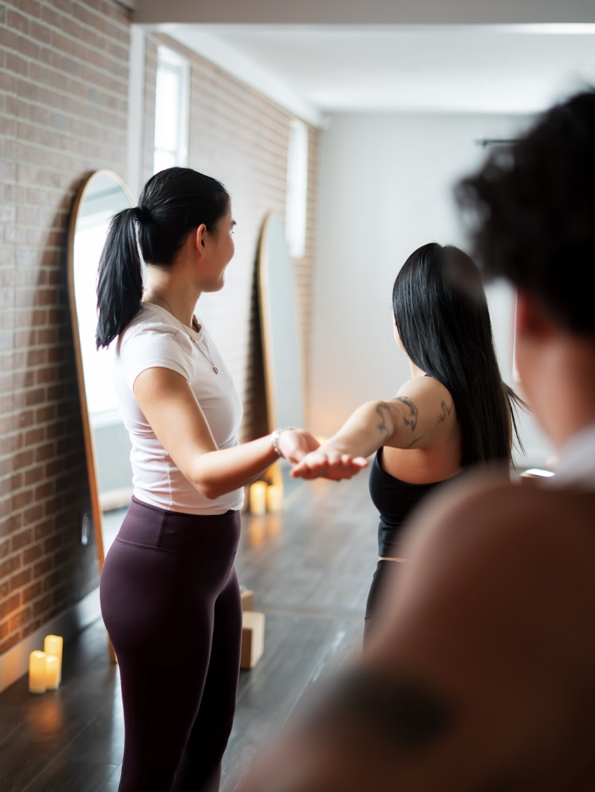 Instructor leading a wellness or yoga class with participants in a studio
