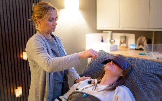 Holistic therapist using crystals during a healing treatment session with a client in a calm therapy room