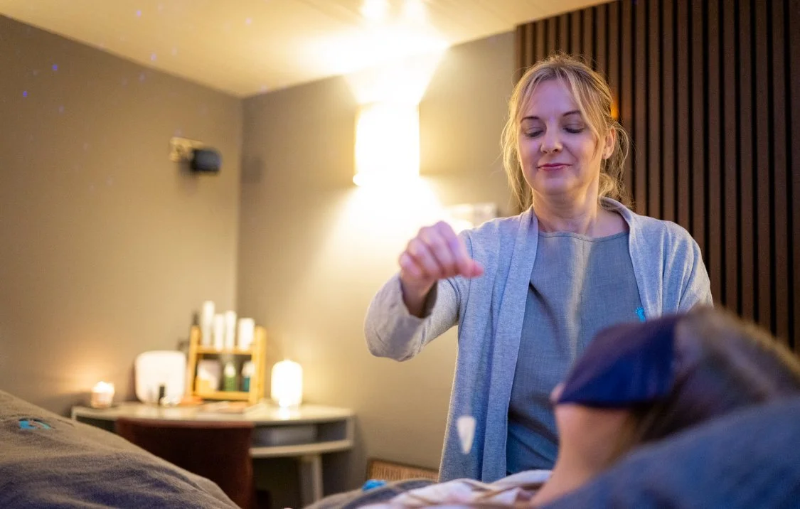 Client receiving crystal healing treatment in a calm holistic therapy room during a relaxation session