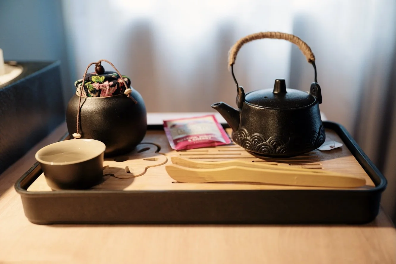 Herbal tea being poured into a mug with teapot, creating a calming self-care ritual scene
