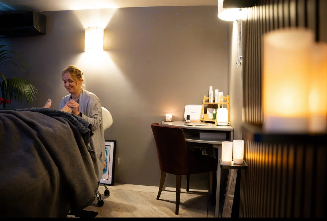 Holistic therapist providing reflexology treatment in a calm treatment room
