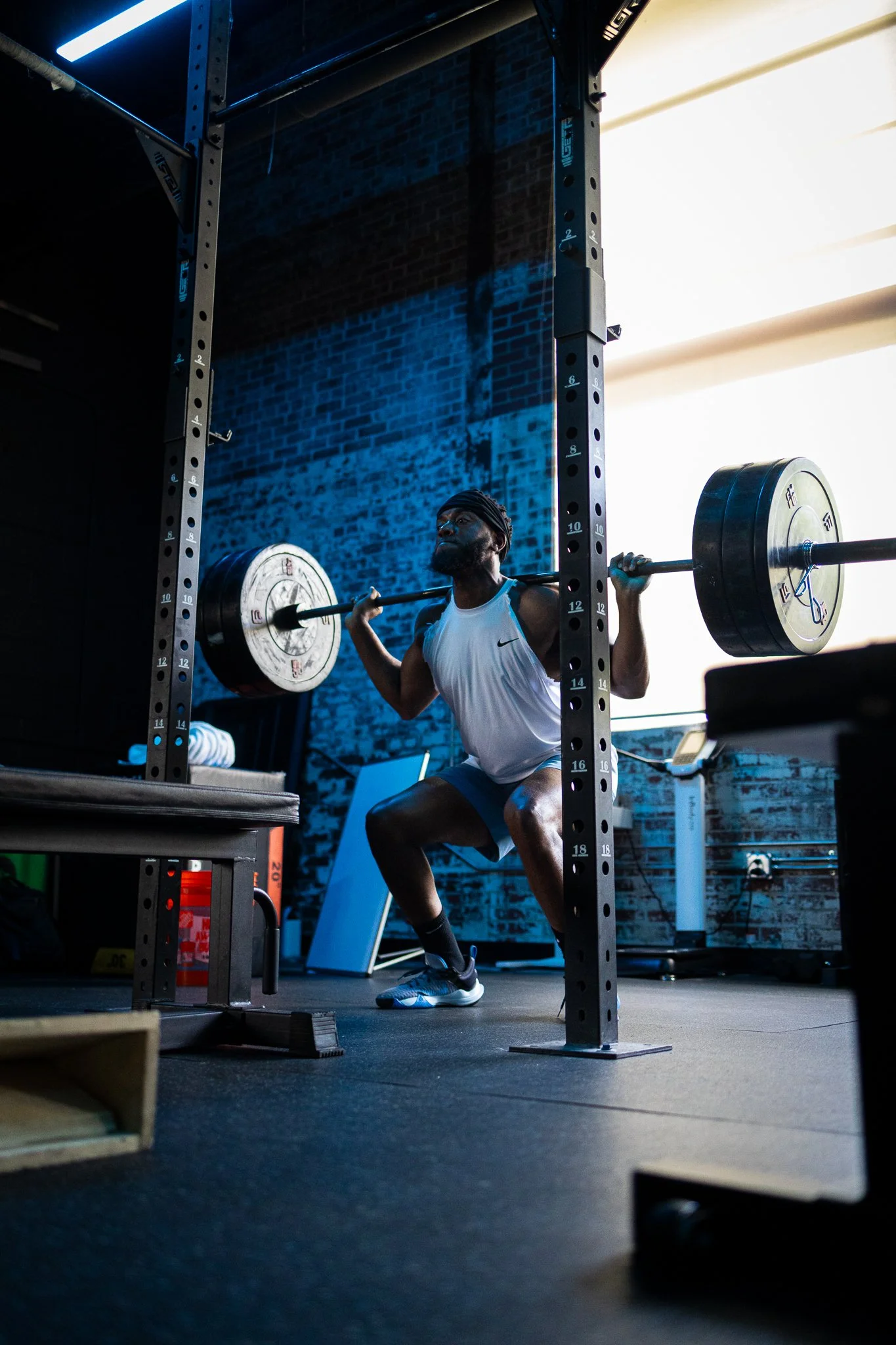 Male athlete performing a heavy squat in fitness facility