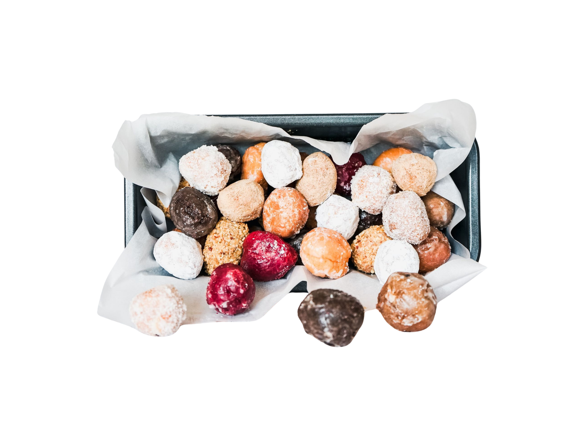 A tray filled with assorted donut holes covered in powdered sugar, chocolate, and sprinkles lined with parchment paper.