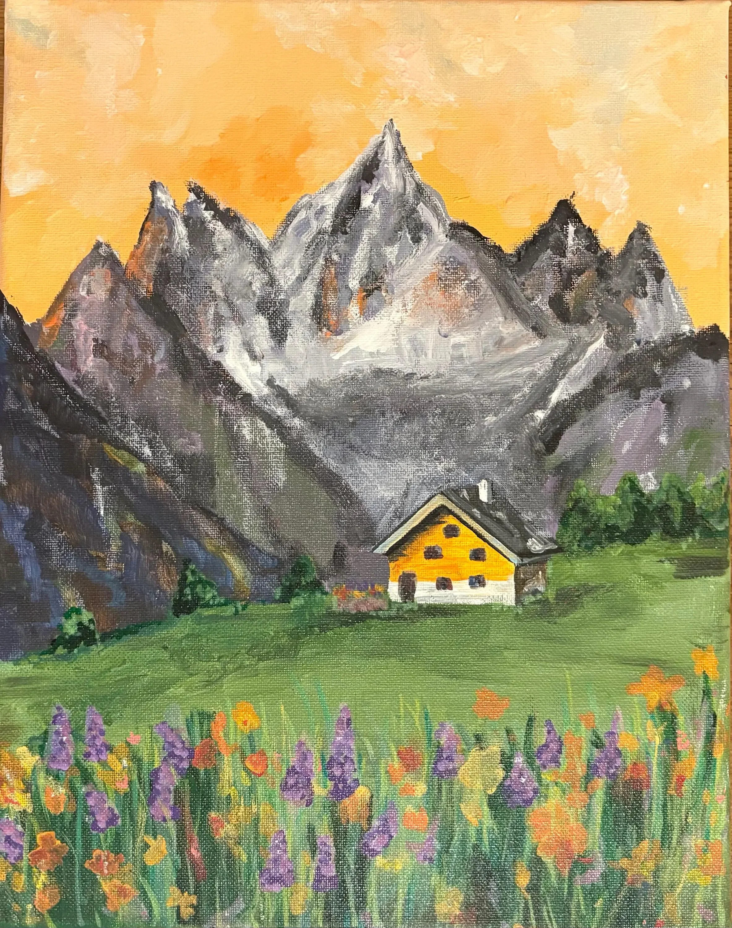 A painting of a mountain range with a yellow-orange sky in the background. At the base of the mountains, there is a small house with a yellow roof and dark windows amid a green field with colorful flowers.
