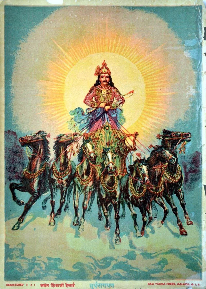 A colorful illustration of a Hindu deity riding a chariot drawn by six horses. The deity is adorned with a crown, jewelry, and holds a weapon. A radiant halo surrounds the deity's head, with rays extending outward.