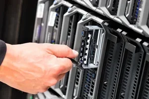 A person installing or removing a hard drive in a server rack.