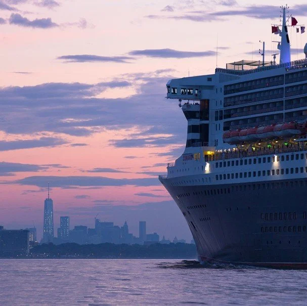 The ocean liner Queen Mary 2 sailing towards New York City's skyline at sunrise as taken by NYC Media Boats.