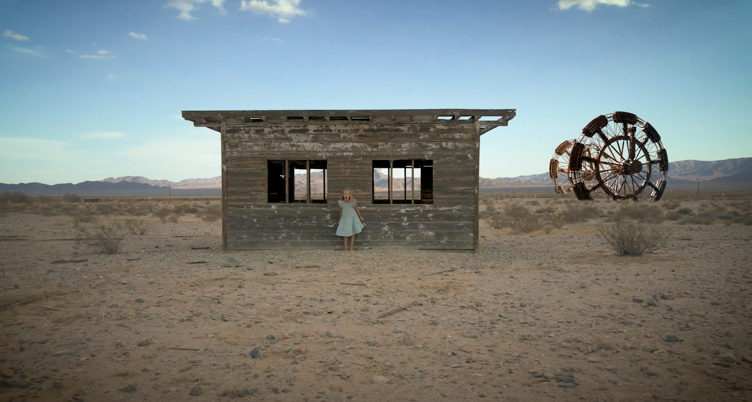 Image of a young girl in front of a cabin in the Seether music video. 