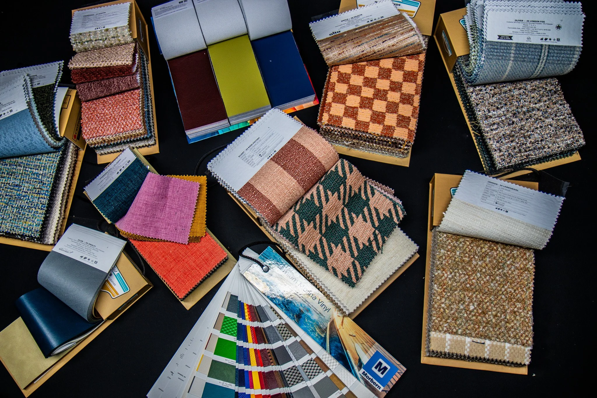 Display of various fabric samples, color swatches, and texture patterns arranged on tables for selection or comparison.