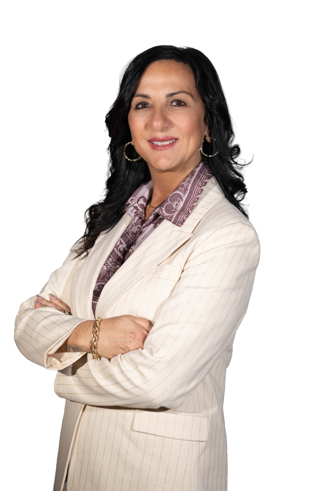 Angela Saggese standing with arms crossed, wearing a light blazer, photographed on a white background.