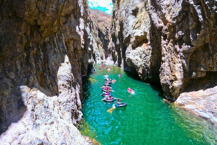 People floating in the water of Somoto canyon with high rocky walls.