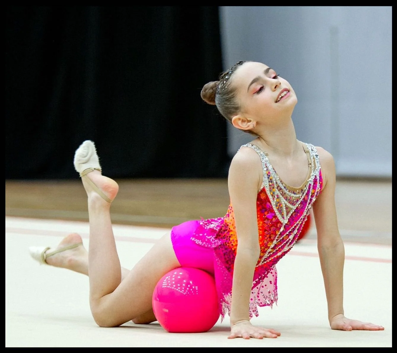 Competitive rhythmic gymnast performing a ball routine at competition for Elite Rhythmic Centre.