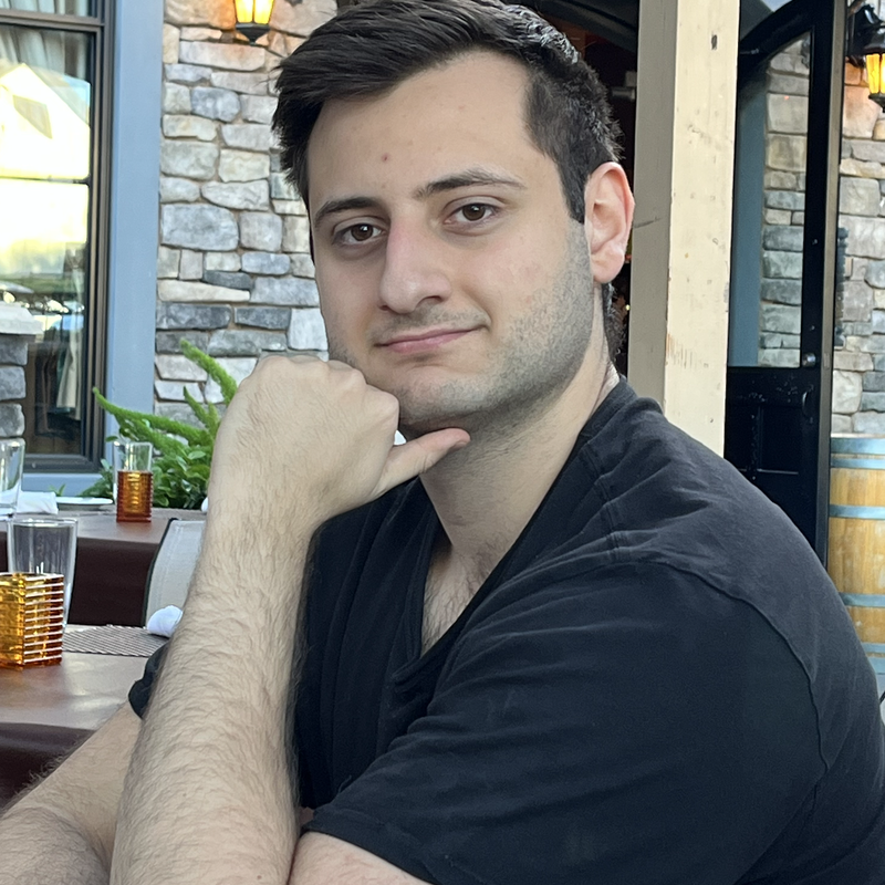 Stefan Ivanovic, the founder and CEO of ReinBio, and the inventor of GReinSS, is sitting at a restaurant table with a thoughtful expression.