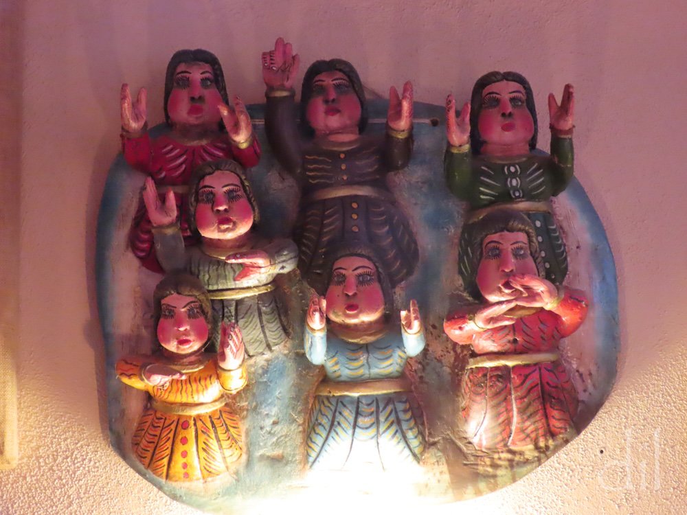 In Santa Fe one's eyes are never at rest. The Shed's walls, too, are graced with regional works. This painted clay Mexican folk art depicts seven women engaged  in some form of ceremonial worship.