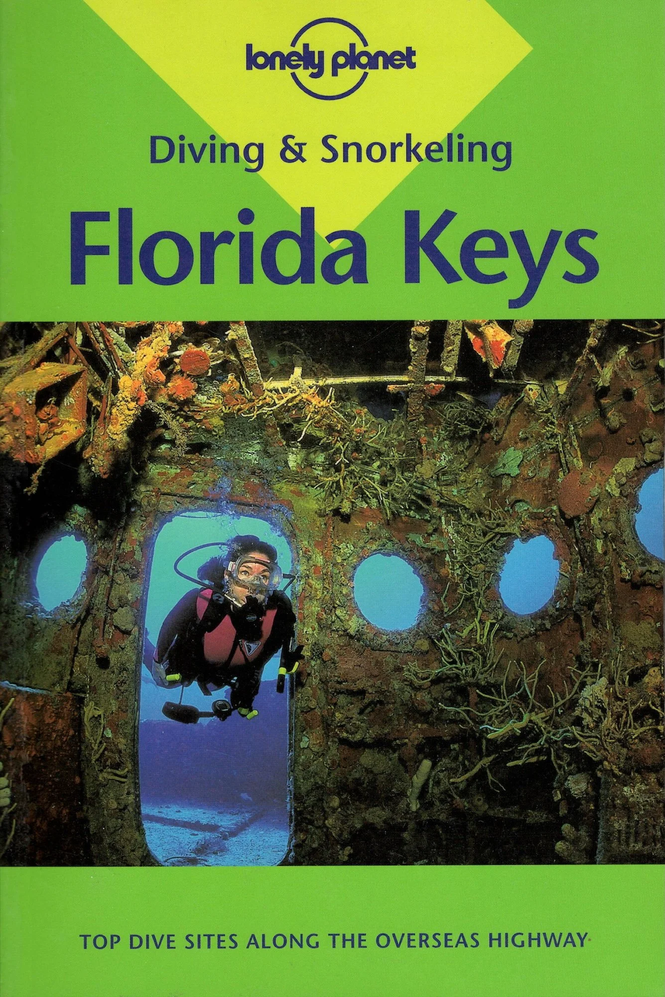 A cover of a guidebook titled "Lonely Planet Diving & Snorkeling Florida Keys" featuring a scuba diver in front of a coral-covered archway underwater, with the subtitle "Top dive sites along the Overseas Highway."