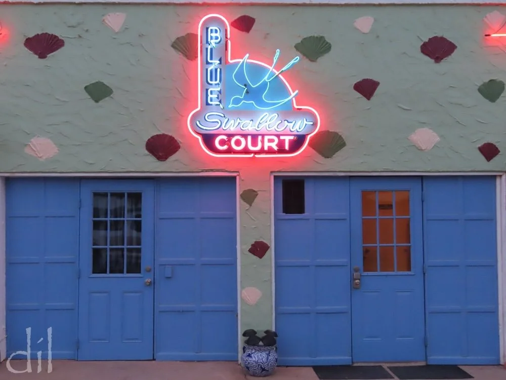 Most evenings in the courtyard of the Blue Swallow, guests recline by their doors in lawn chairs to bathe in neon and relax to tunes of the 1940s and '50s.