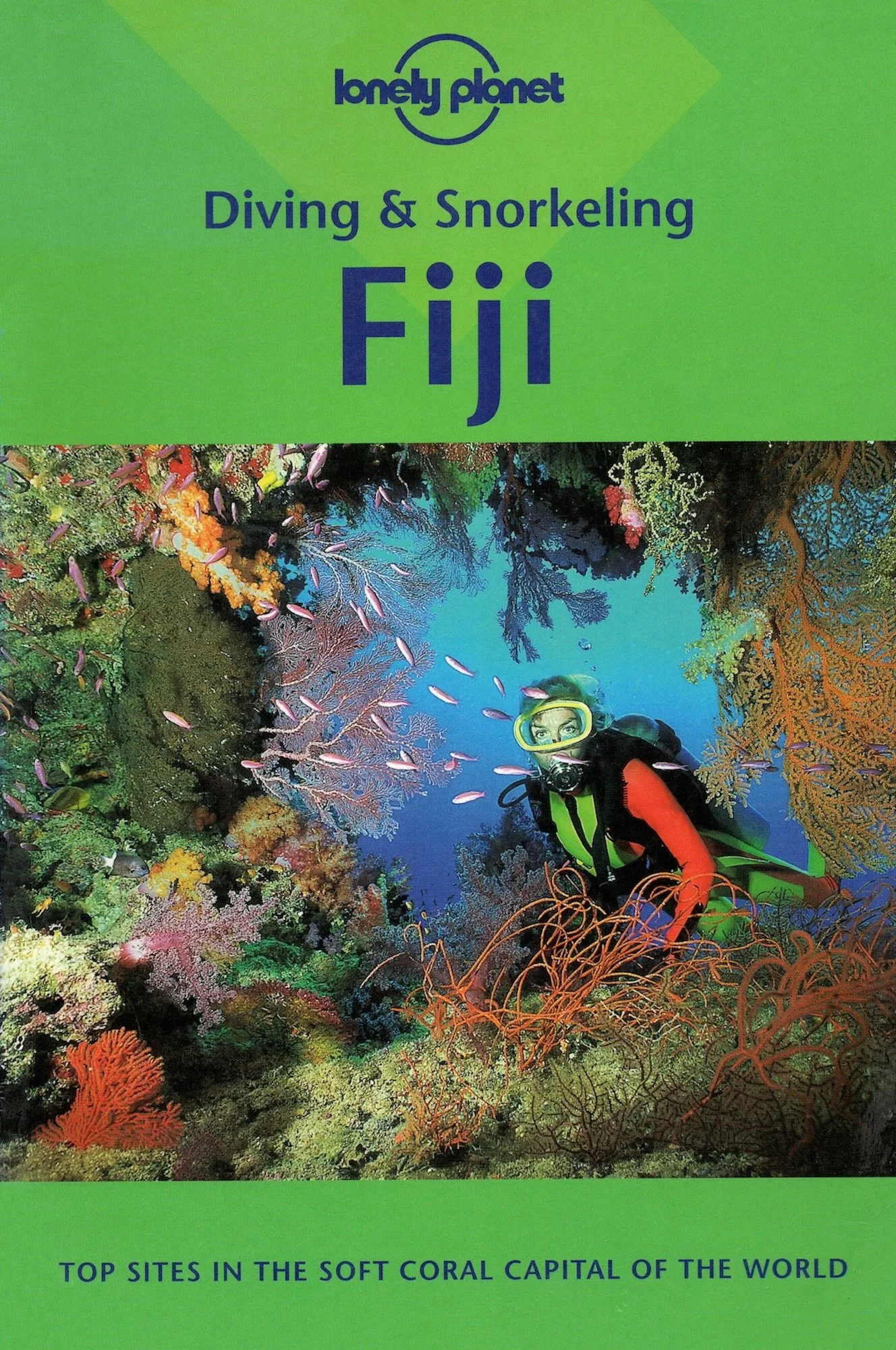 Lonely Planet's diving & snorkeling guide to Fiji. A colorful underwater scene with coral reefs and a diver wearing a yellow mask and wetsuit, exploring the reef.
