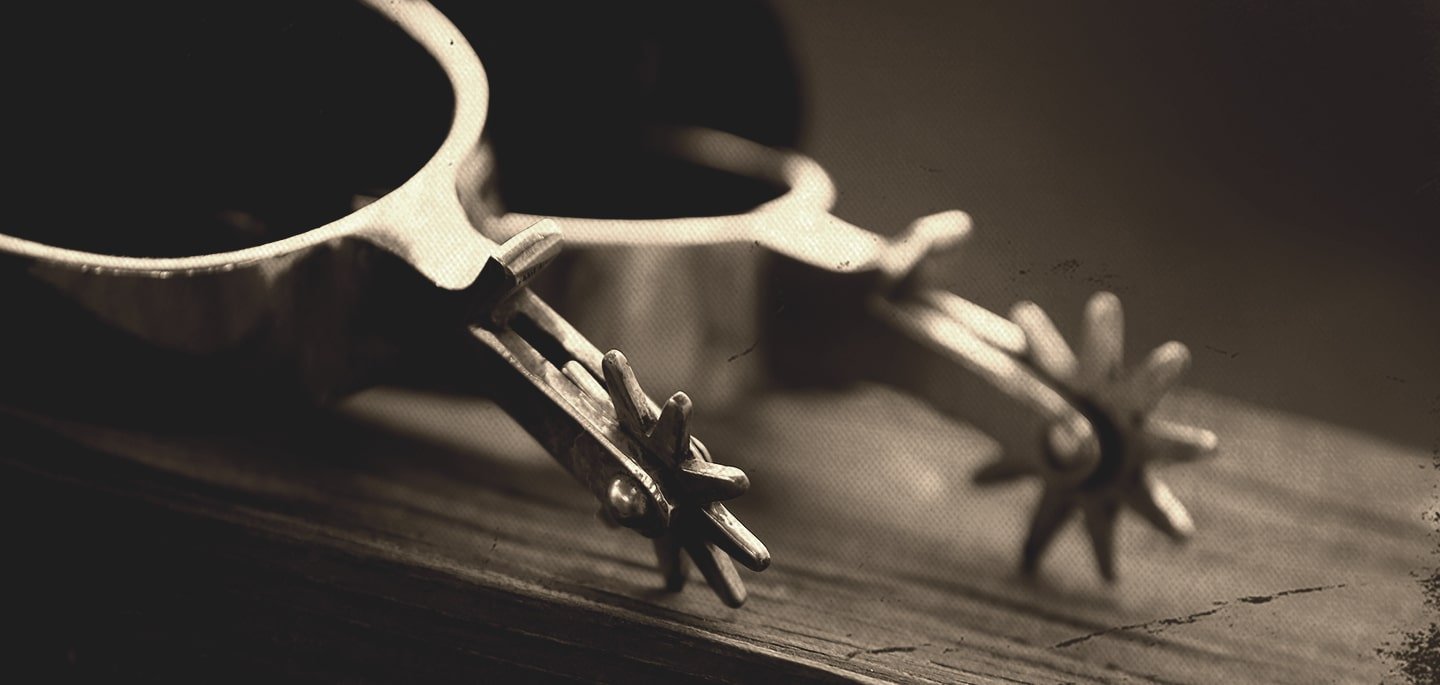 Close-up of a metal crown of thorns resting on a wooden surface.