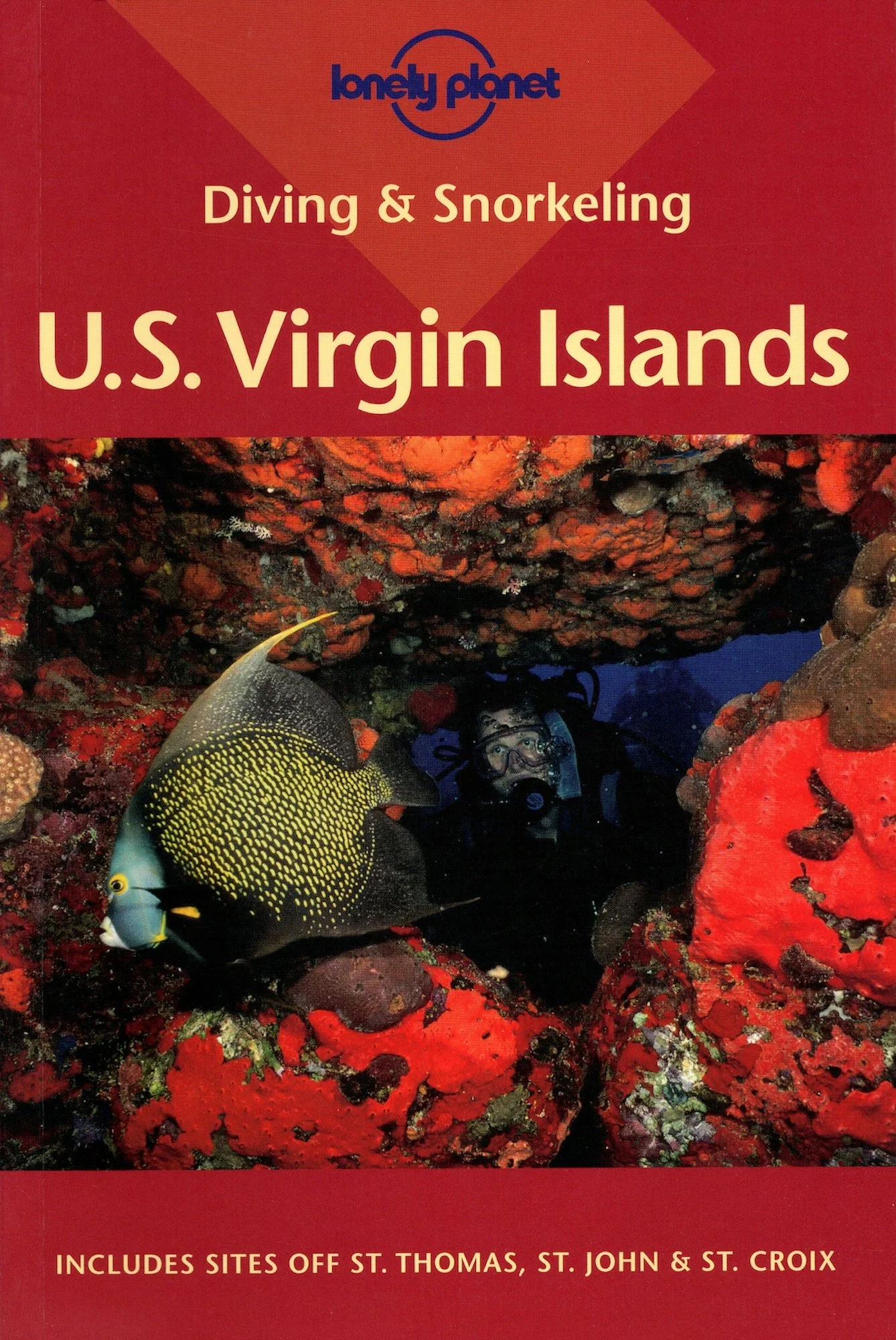 The cover of David Lauterborn's guidebook Diving & Snorkeling U.S. Virgin Islands for Lonely Planet. A scuba diver underwater surrounded by bright red corals and two colorful fish.