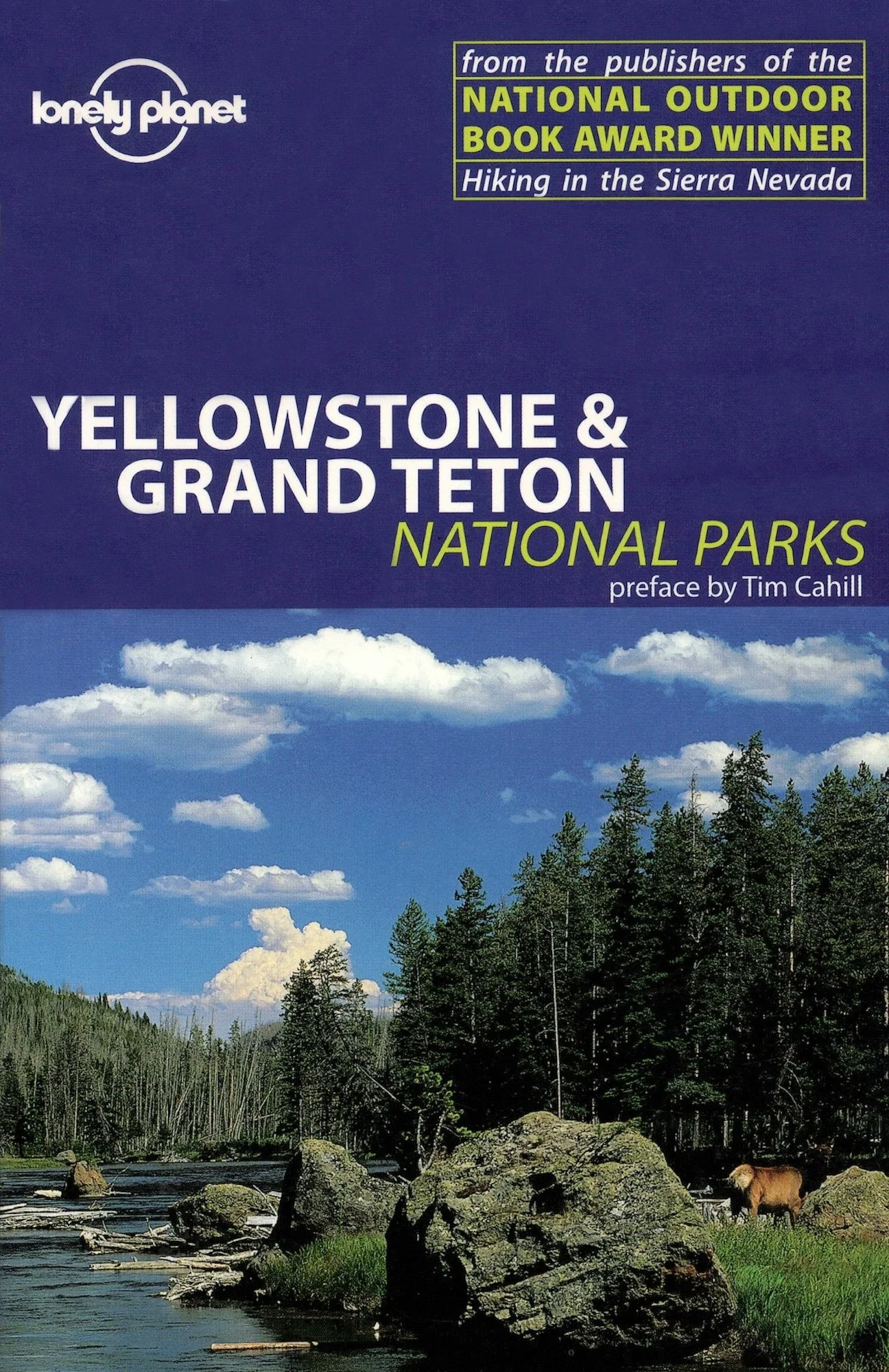 Cover of a Lonely Planet book titled 'Yellowstone & Grand Teton National Parks,' featuring a scenic landscape of trees, rocks, and a river with a blue sky and white clouds overhead.