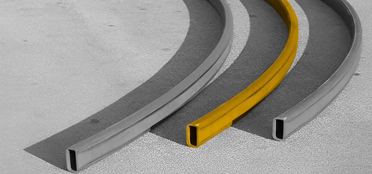 Three curved metal bars, one yellow and two gray, placed on a textured surface.