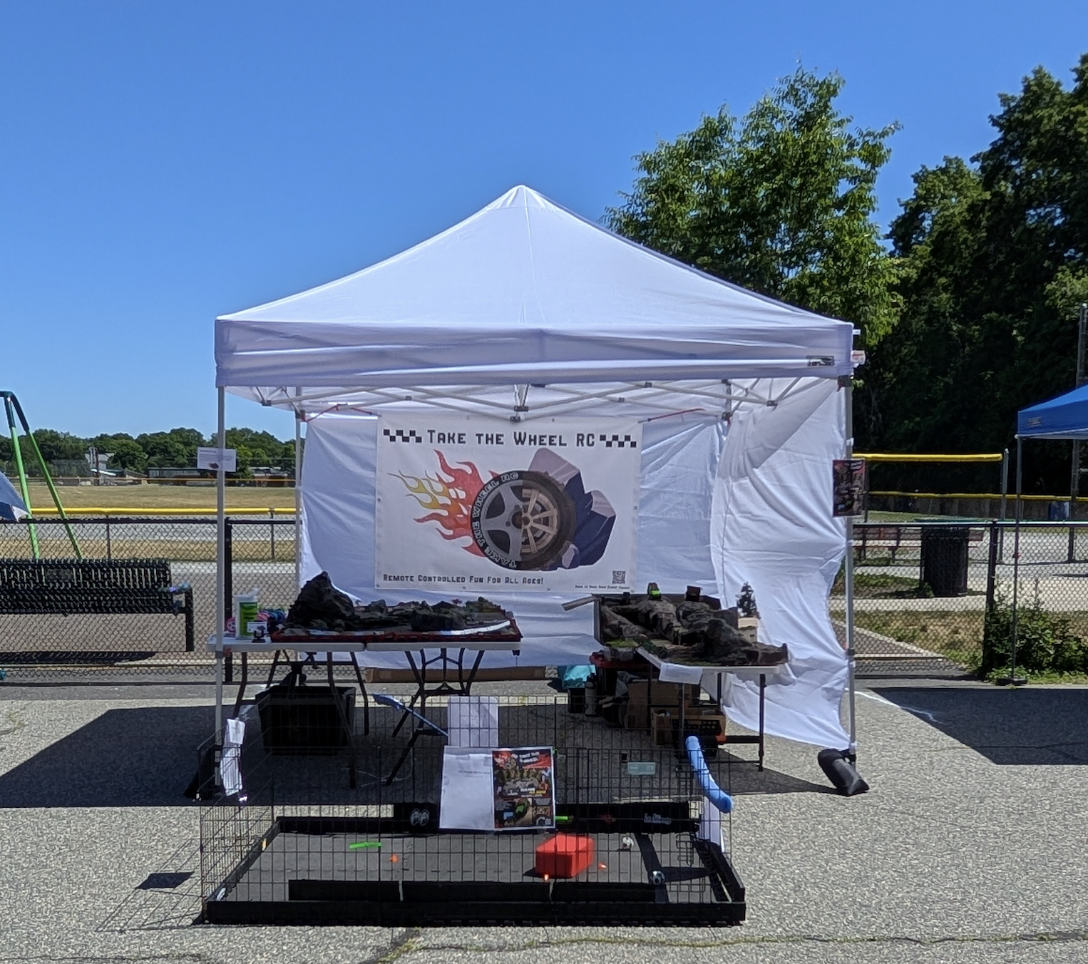 Outdoor event booth with a white canopy tent moments before the fair begins.