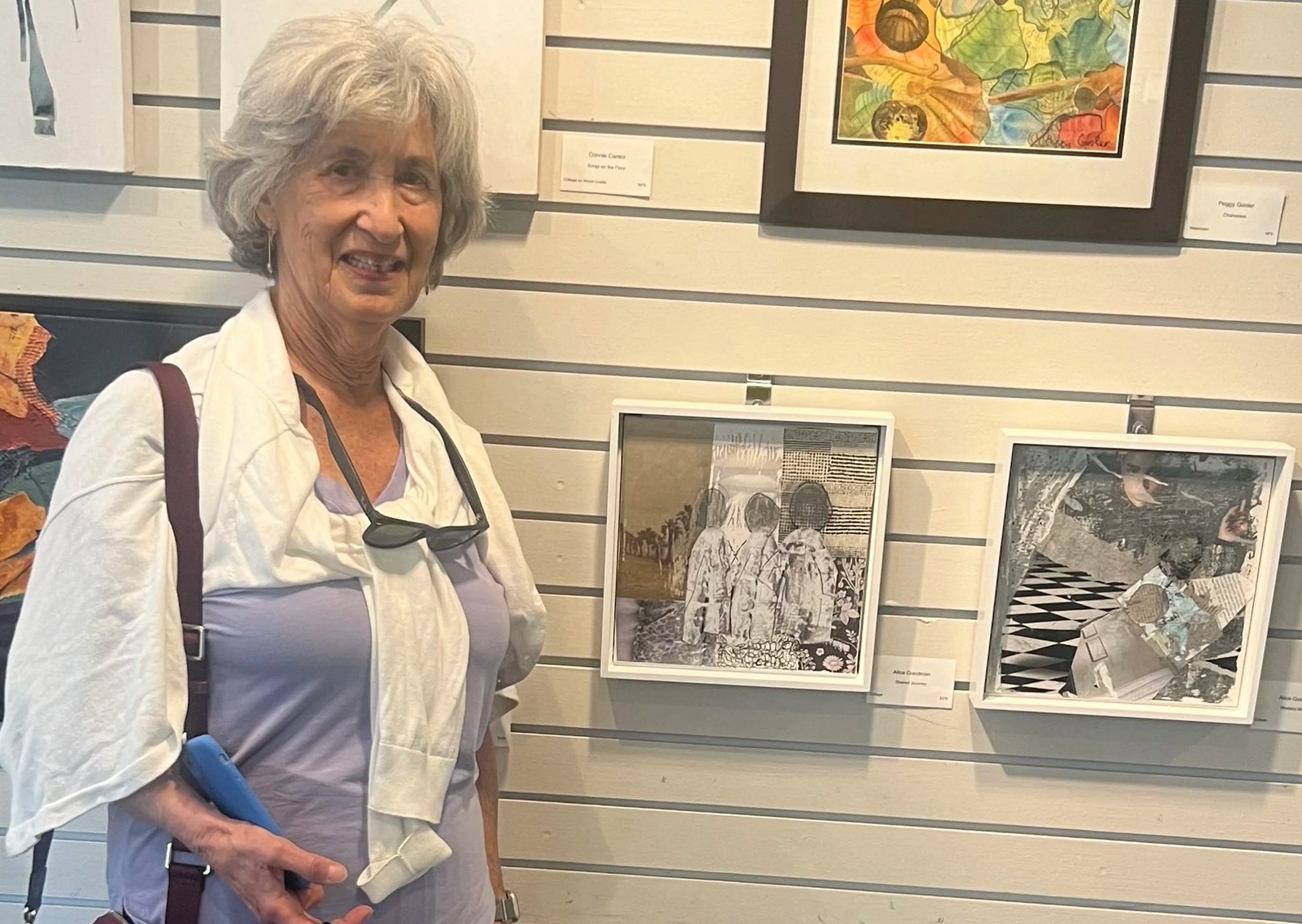 Alice Goodman standing in front of her art displayed in an art gallery