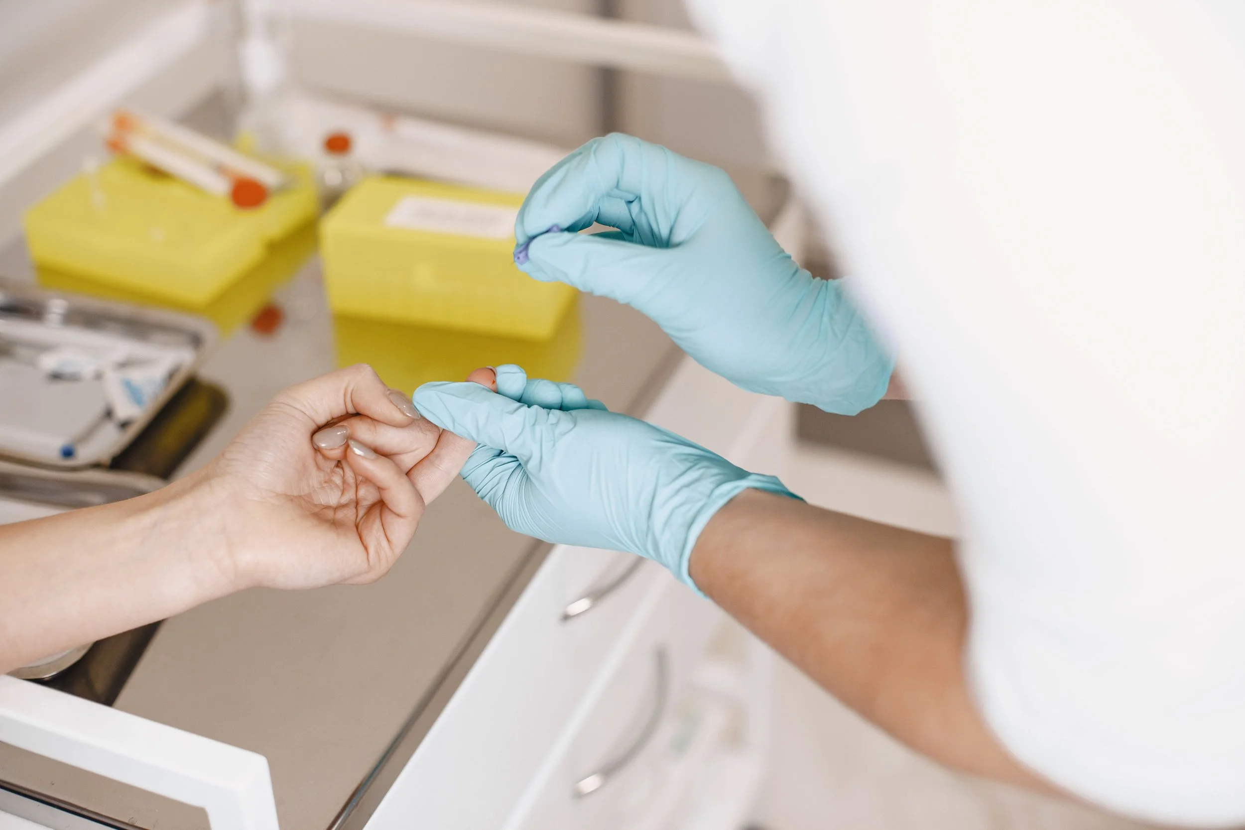 Pediatric nurse practitioner performing a finger-stick blood test on a child during an office visit at Rowe & Co. Pediatrics in Baton Rouge, Louisiana.