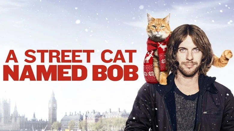 Bob the ginger cat standing on the shoulder of Luke Treadaway as James Bowen in A Street Cat Named Bob.