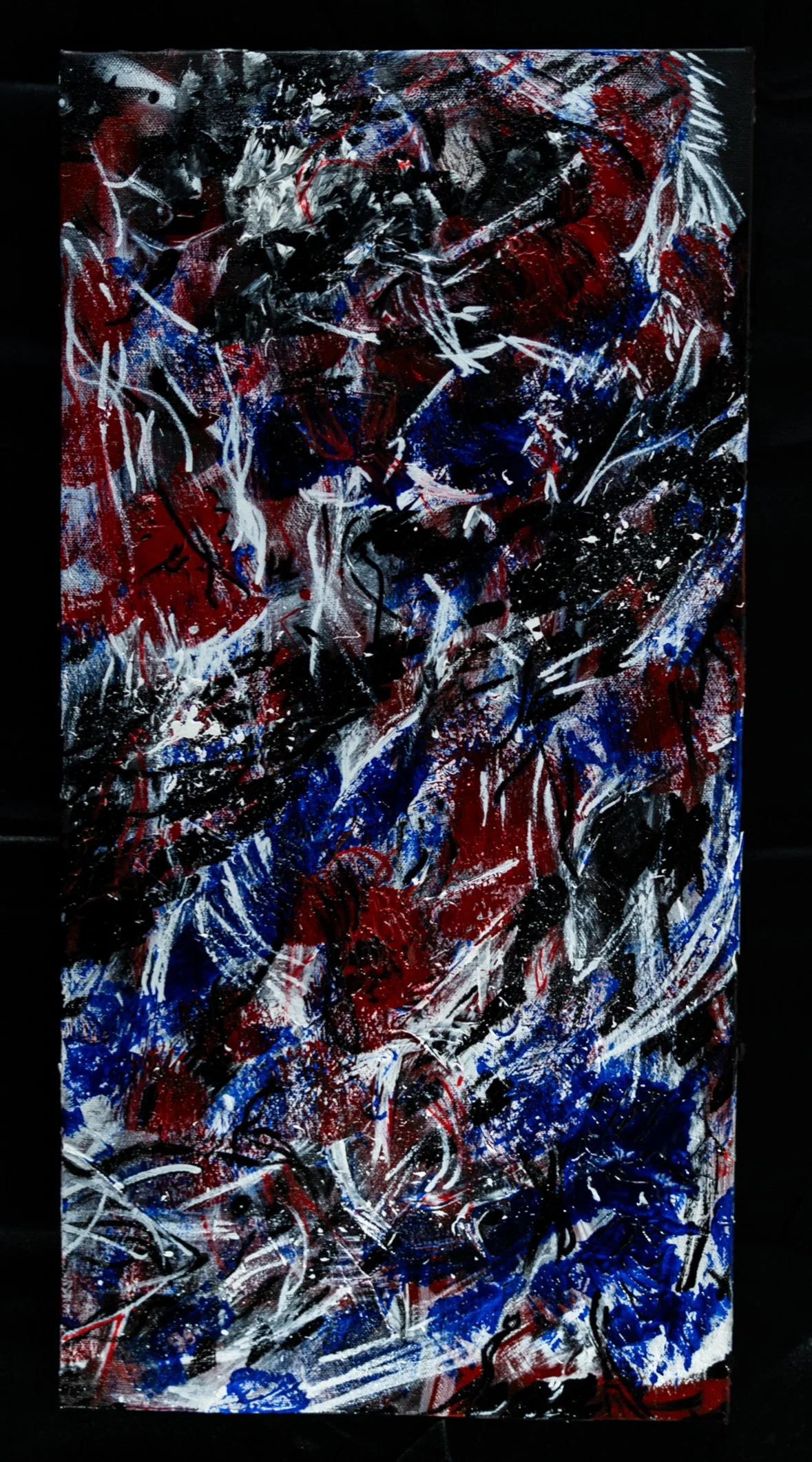 Abstract painting with red, white, blue, and black splashes and streaks, creating a chaotic and energetic composition.