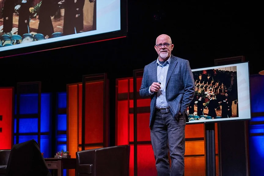 Tom Medema addresses an audience from the stage during Calvin January Series.