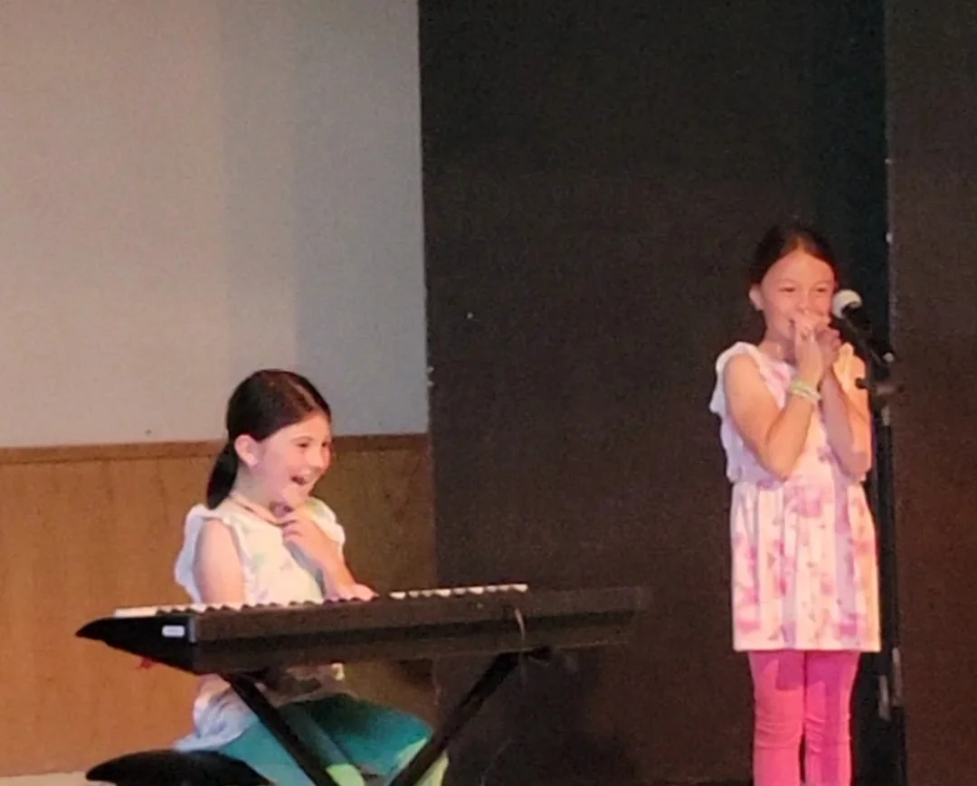 One of my Students (sitting at the piano) performing in the talent show with her friend. I went, and they did a great job!