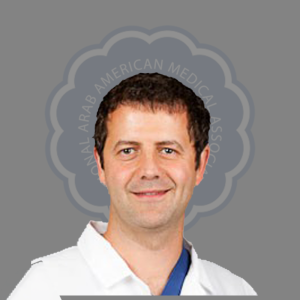 Portrait of a male doctor with dark hair, wearing a white coat, smiling against a gray background with a circular logo of the Arab American Medical Association.