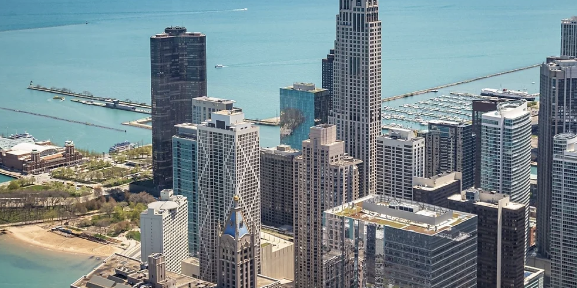Aerial view of Chicago skyline with tall modern skyscrapers and Lake Michigan in the background.