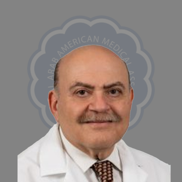 A man in a white medical coat with a patterned tie, bald on top with a brown beard, in front of a gray background with a logo reading 'Arab American Medical Association'.