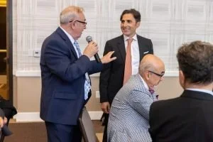 Group of men engaged in conversation at a professional event or conference.