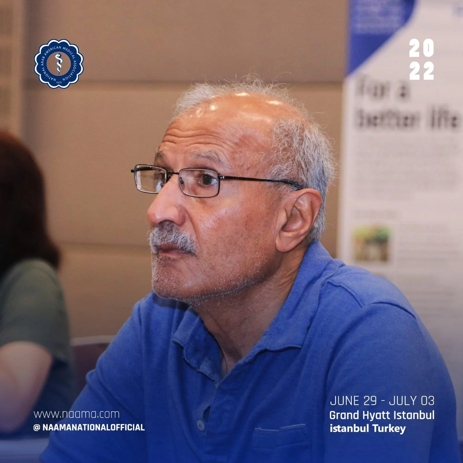 A bearded man with glasses and gray hair wearing a blue shirt, sitting indoors at an event. Text overlay indicates the event dates, location, and website details for NAAM's 2022 conference at Grand Hyatt Istanbul in Turkey.