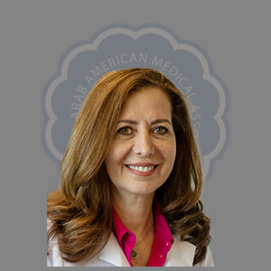Portrait of a woman with brown hair wearing a white lab coat and pink blouse, smiling, against a gray background with text.