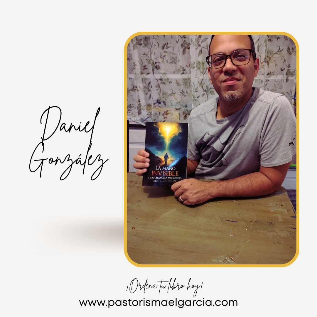 Hombre con gafas sentado en una mesa de madera, sosteniendo un libro titulado 'La Mano Invisible' con un fondo de cielo y una figura humana en la portada. Fondo con cortinas con flores.