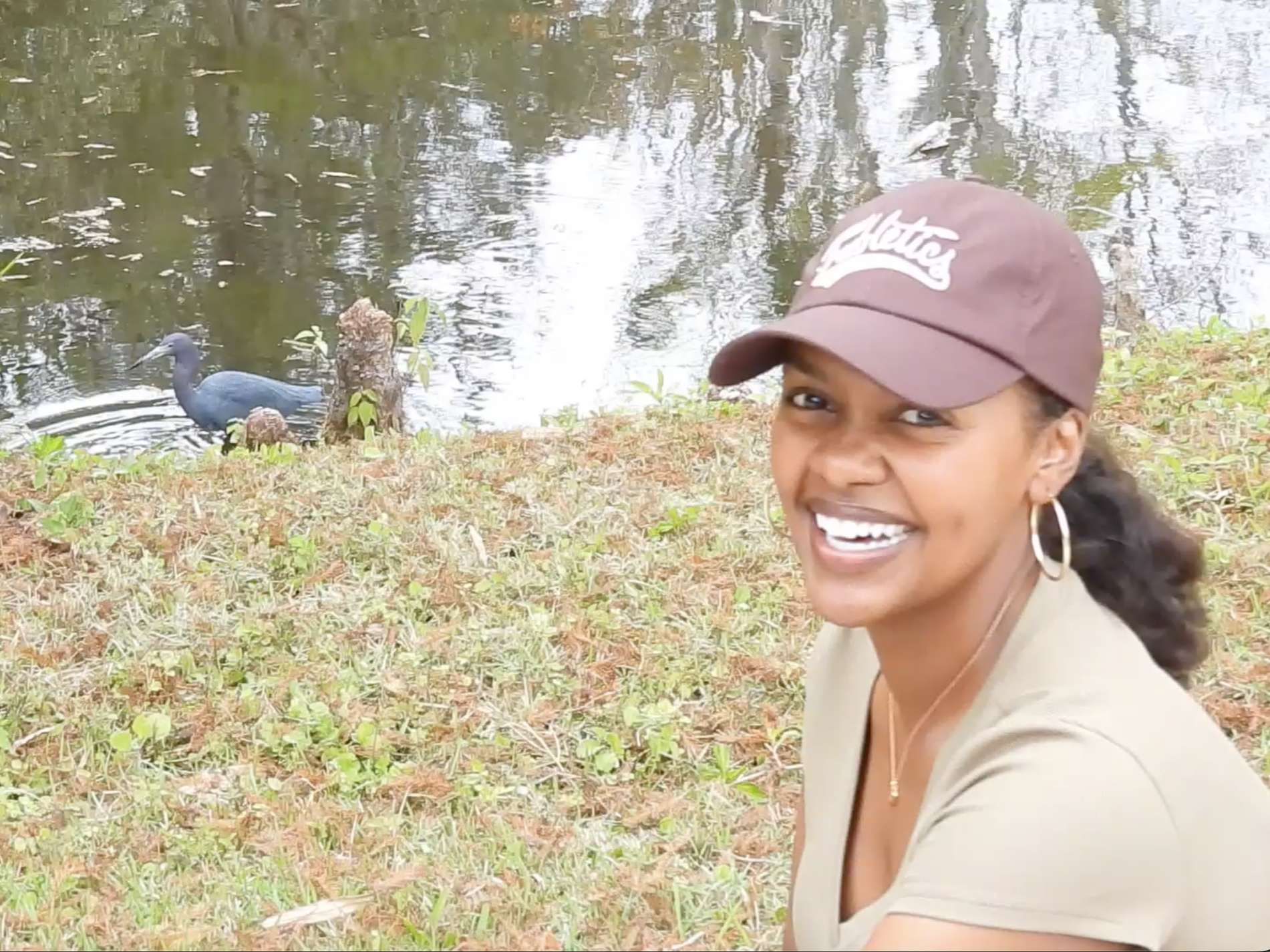 Courtney smiling while observing a heron near the water.