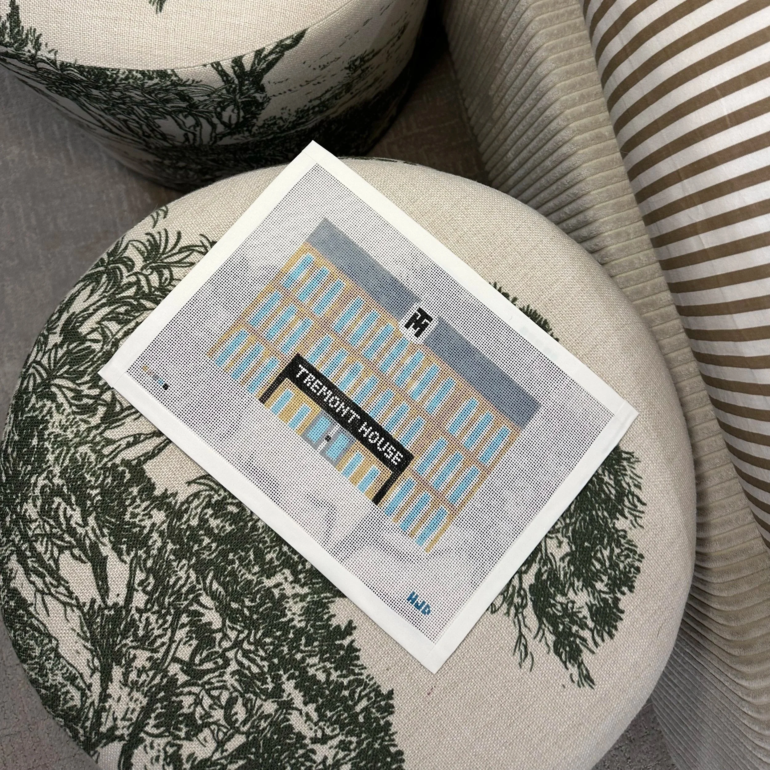 Close-up of a couch with patterned throw pillows and a newspaper on the seat.