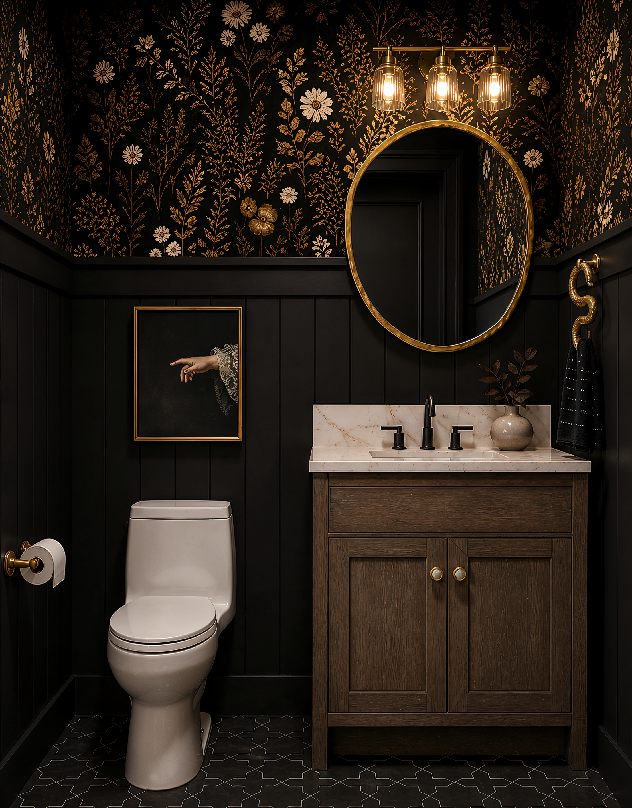 A modern bathroom with black and gold floral wallpaper, a white toilet, a wooden vanity with a marble countertop, a round mirror with a gold frame, and contemporary lighting fixtures.