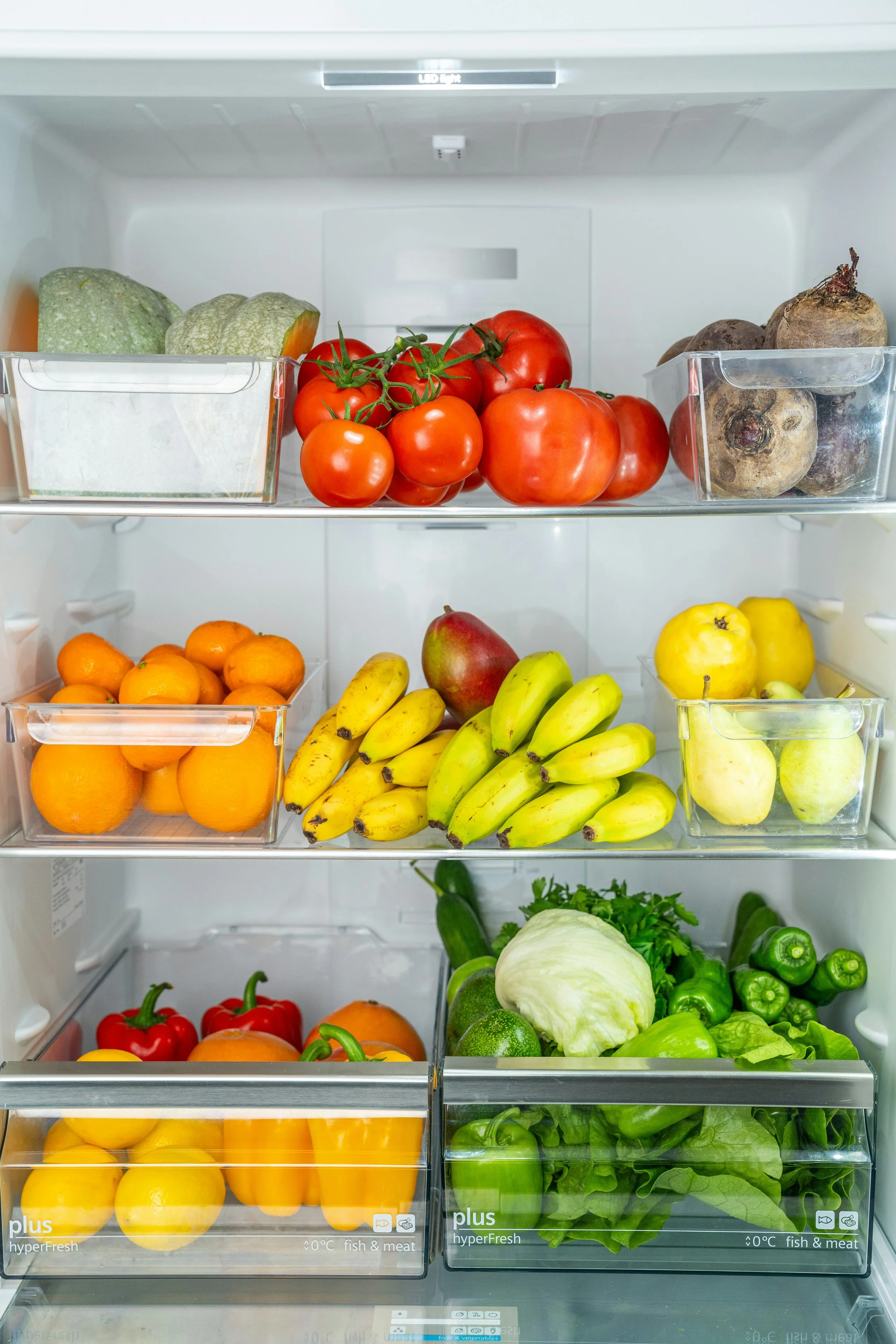 Refridgerator stocked with fresh fruits and vegetables for anti-inflammatory meals and wellness-focused cooking