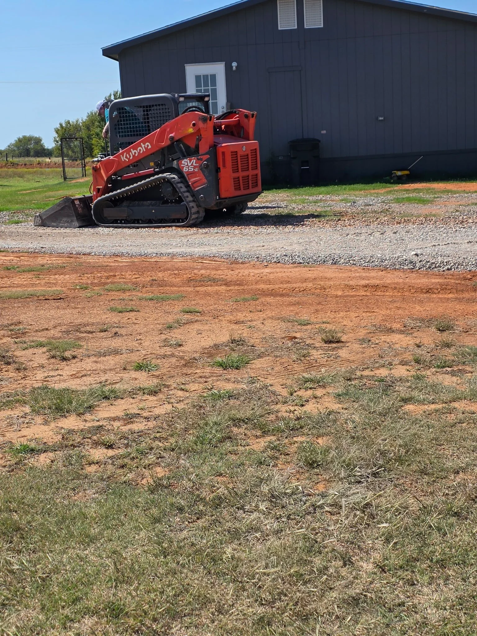 Skid steer grading and spreading gravel for driveway repair by Nubs Services