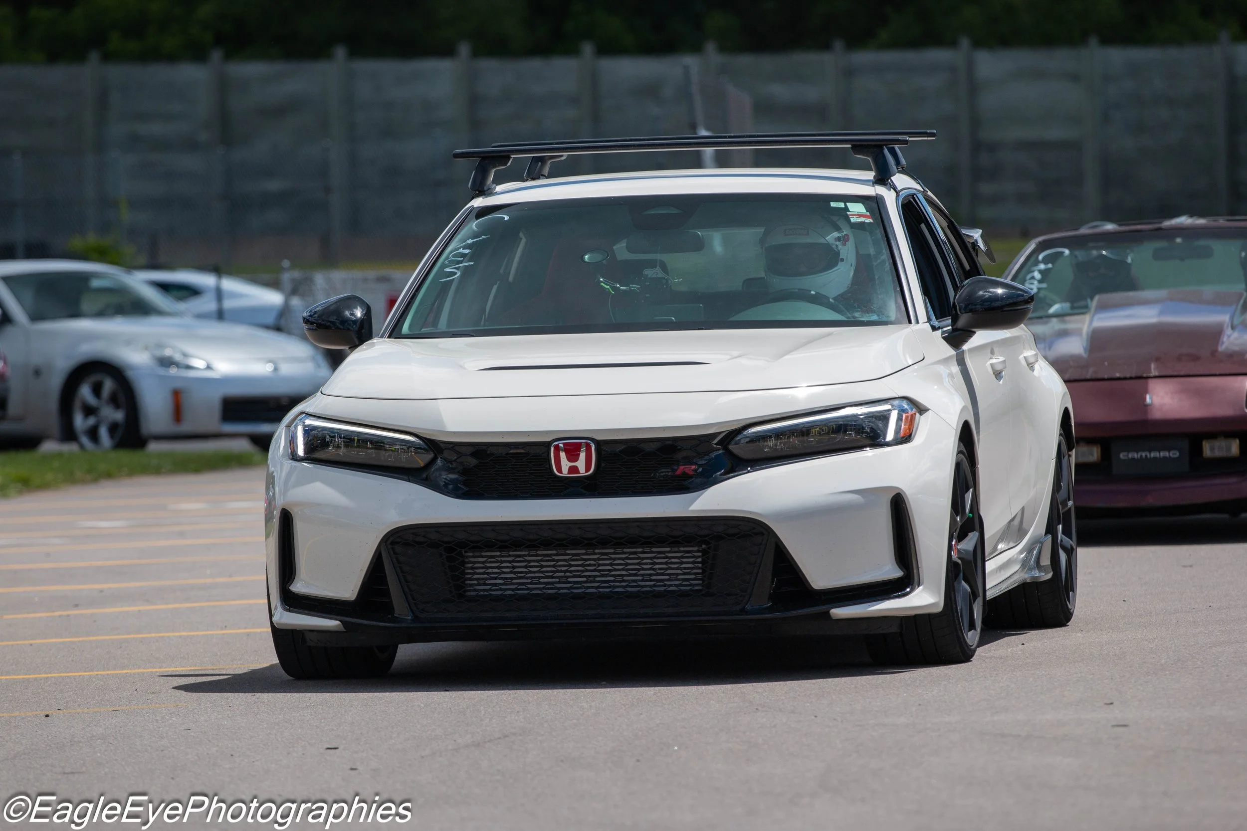 White Honda Civic Type R parked in a parking lot with other vehicles around, including a silver car and a maroon classic car.